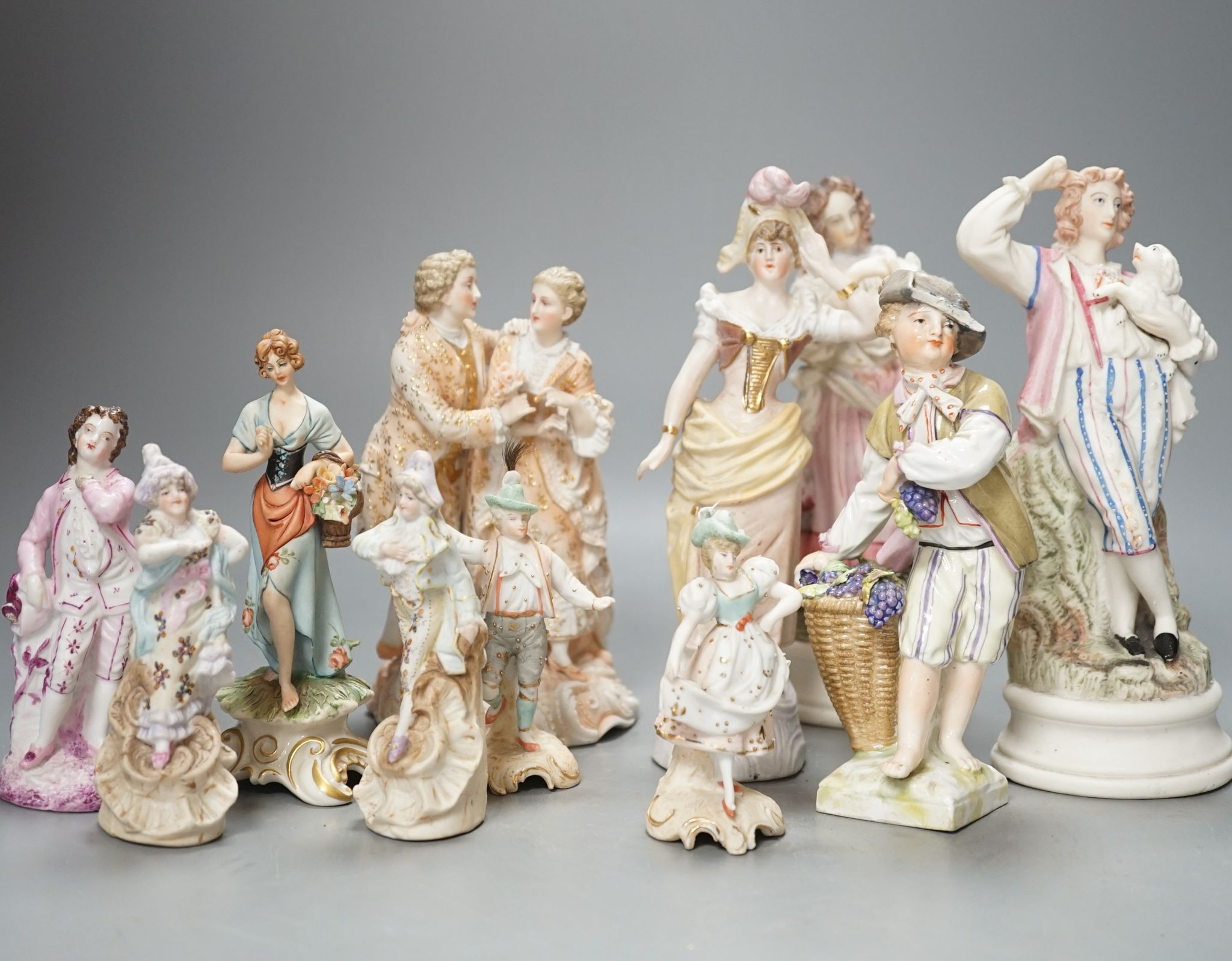 Ten French bisque figures and a Berlin figure of a grape picker, tallest 19cms high.